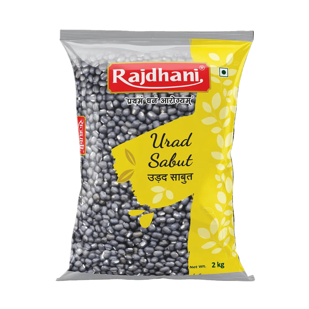 A 2 kg bag of Rajdhani Urad Sabut (black beans) on a plain white background. The packaging features a prominent red Rajdhani logo, a bright yellow graphic on the right, and a clear window showing the dark gray-black beans inside.